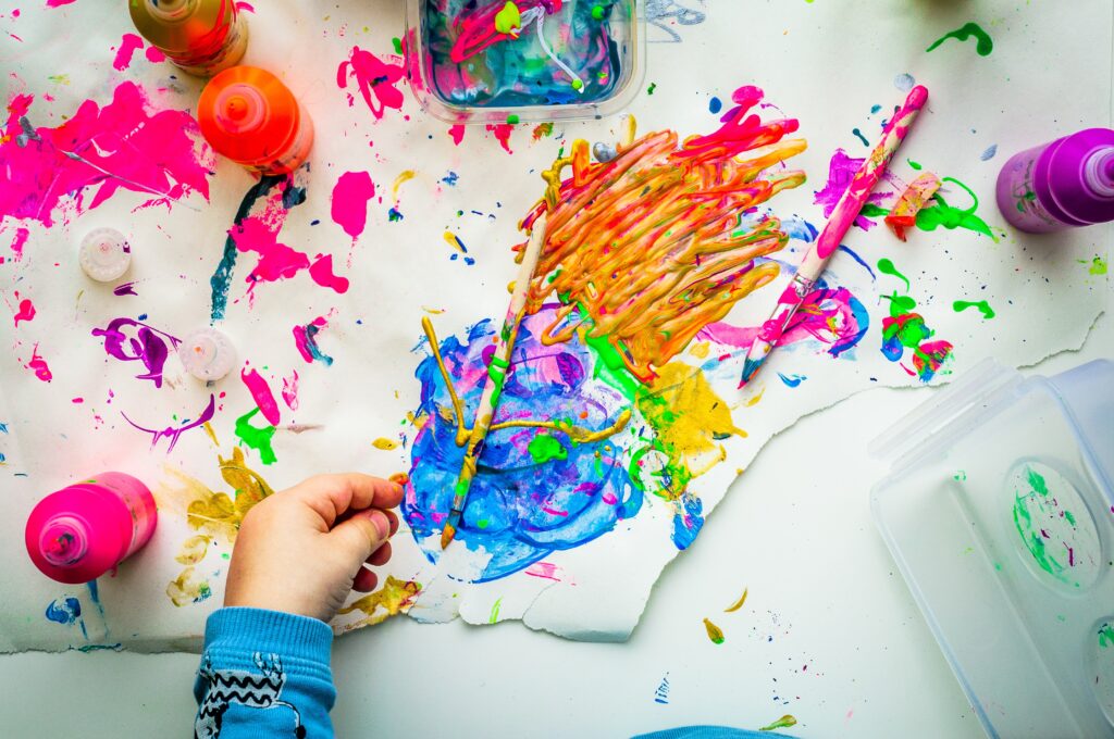 Colorful paint spilled on paper with paint brushes | Indoor Activities for Summer | Merely Creative, Martinsburg WV